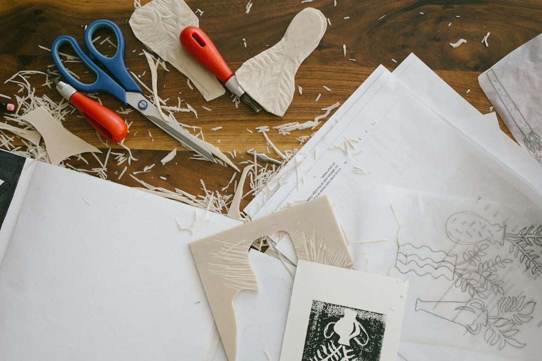 Designer's desk covered with vintage print layouts and drafting tools